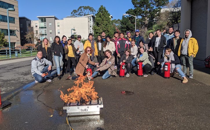 Undergraduates outside next to firepit on campus