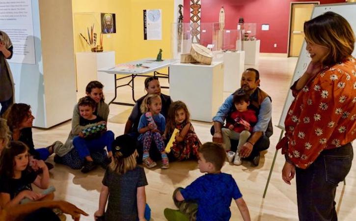 Students sitting in museum listening to presenter