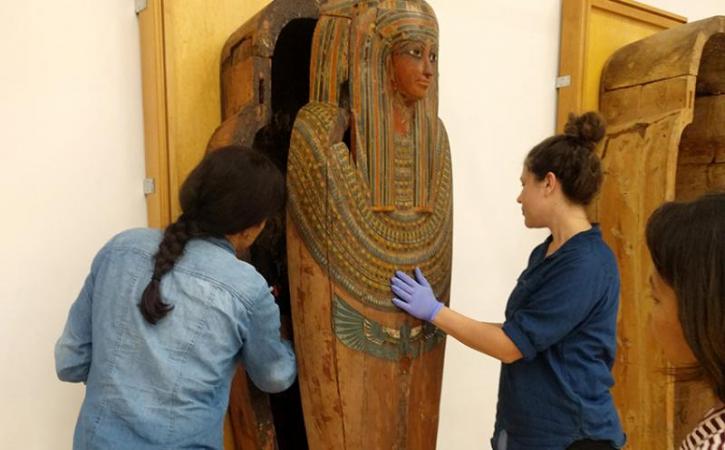 Two students moving sarcophagus