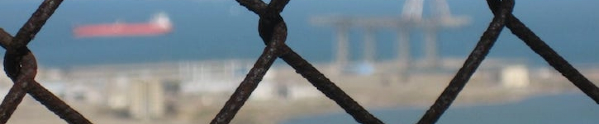 View of SF Bay and Hunter's Point through a chain fence