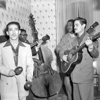 black and white photograph with two Latino men playing maracas and guitar, and two African American men playing a stand up bass and guitar