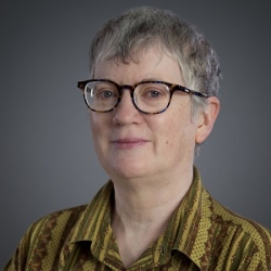 Barbara Eaton is a white wonam with short gray hair, light skin and is wearing glasses