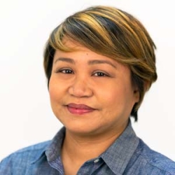 Christine Fogarty is an Asian woman with short brown and blonde hair. She is wearing a blue shirt.