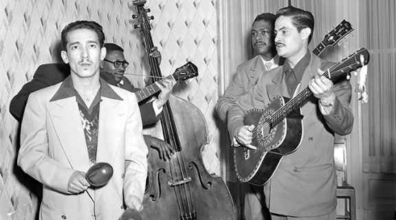 black and white photograph with two Latino men playing maracas and guitar, and two African American men playing a stand up bass and guitar